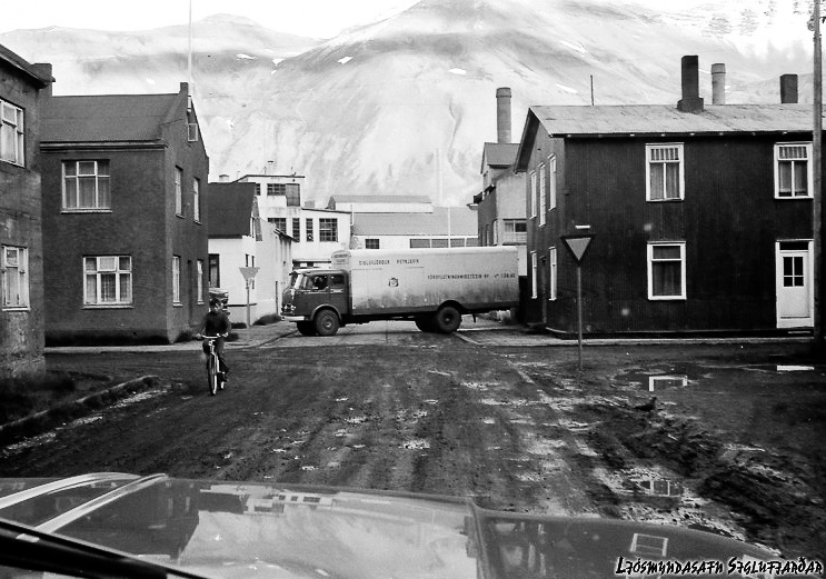 Á horni Eyrargötu og Norðurgötu, Rauða Myllan svokallaða í bakgrunninum og vörufluttningabíll Bigga Run. Ljósmyndari: Steingrímur Kristinsson.